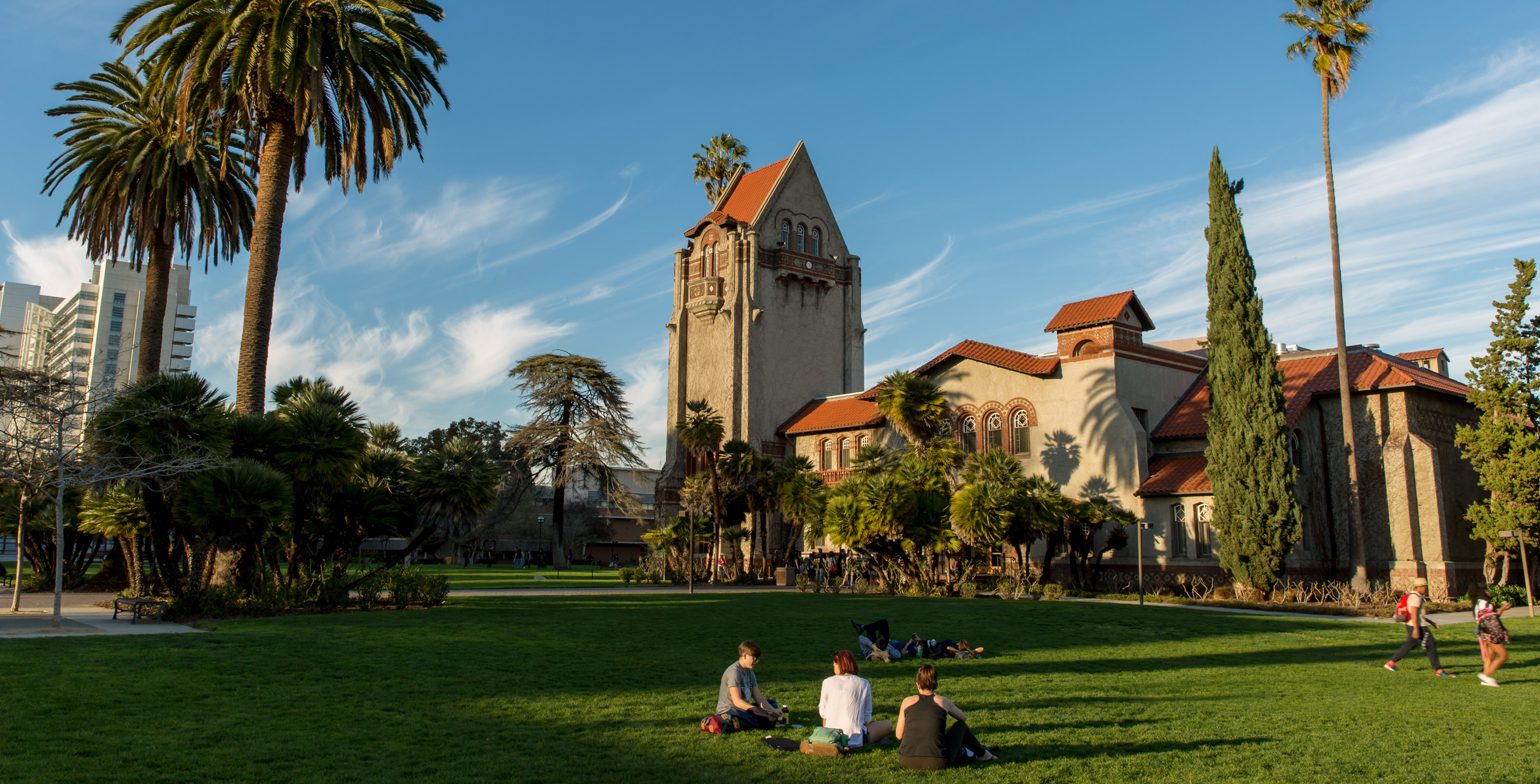 A green Tower Lawn below and a blue sky above, with Tower Hall featuring center and prominent.
