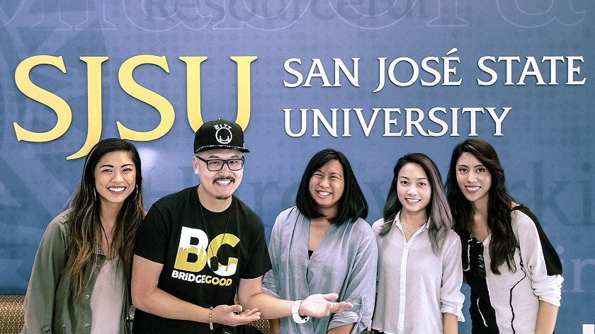 alumni in front of sjsu sign