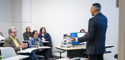 person stands, giving their presentation in presentation room