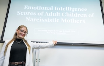 person gestures proudly in front of presentation opening slide