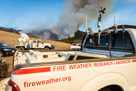 wildfire research truck sits in front of burning hillside