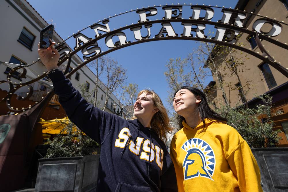 Students taking a photo in front of the San Pedro Square entry gate in downtown San Jose.