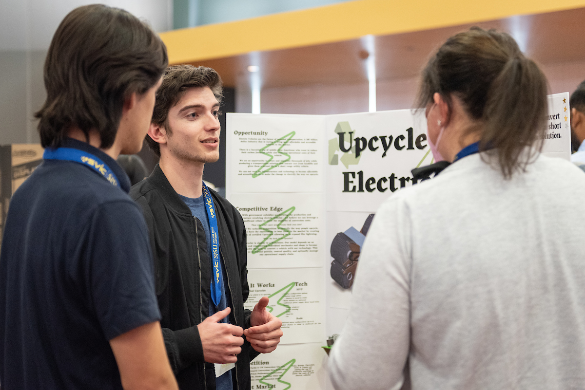 Students giving a presentation on sustainability principles.